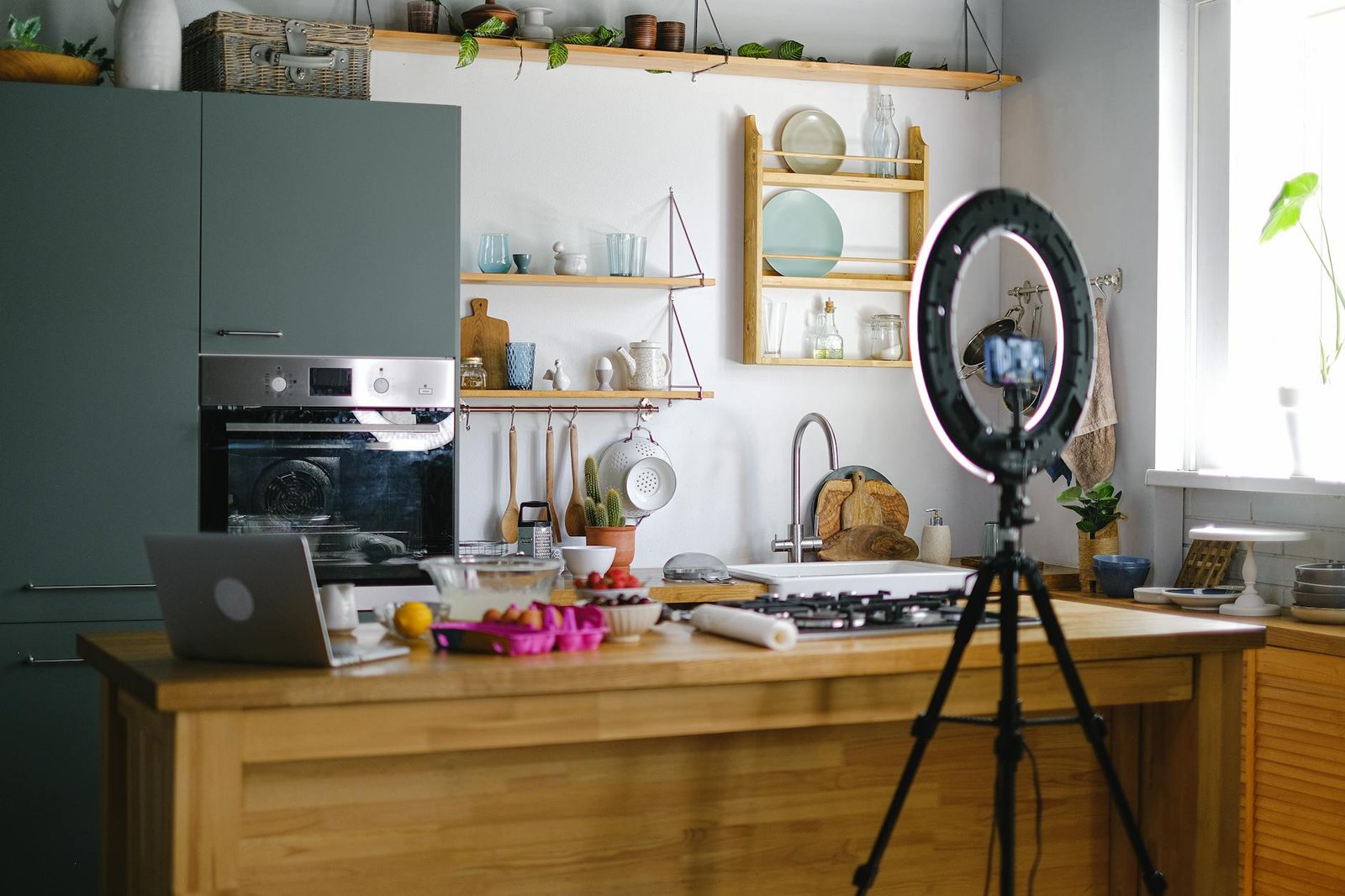 smartphone on a tripod and a laptop on a kitchen counter