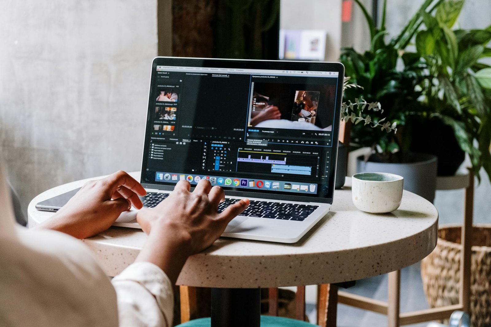 person using macbook pro on white table